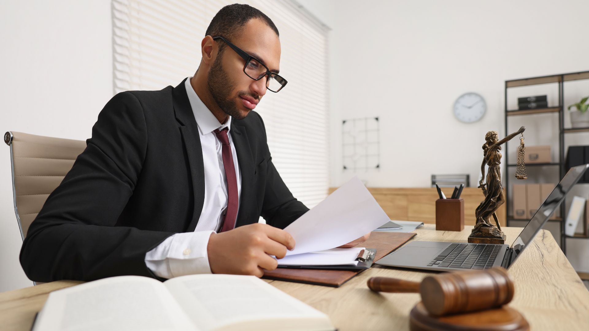 Attorney reviewing legal documents at a desk with a laptop